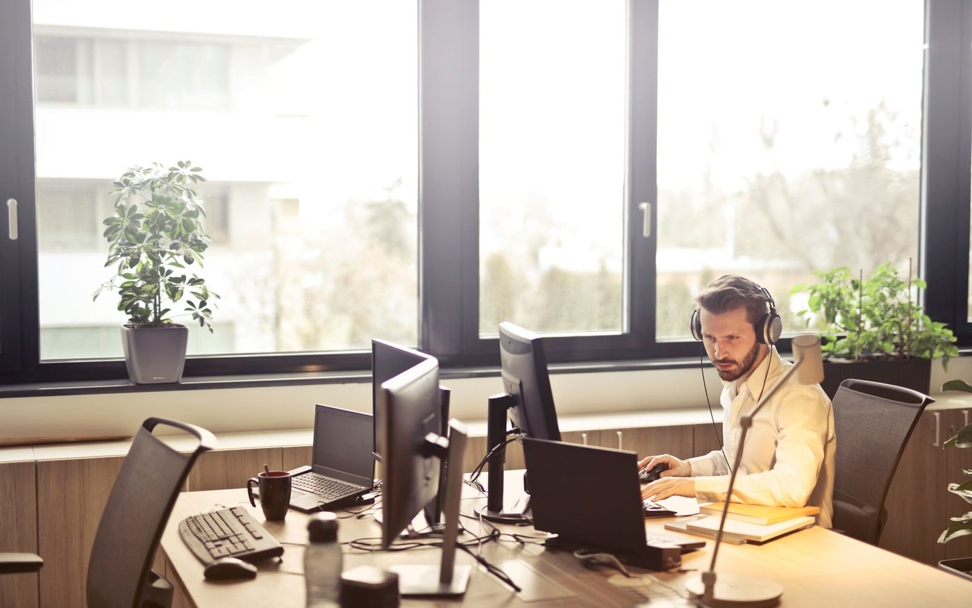 Mitarbeiter mit Headset arbeitet am Bildschirm